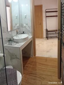 bagno con lavandino bianco e specchio di N&S Apartment A a Édessa