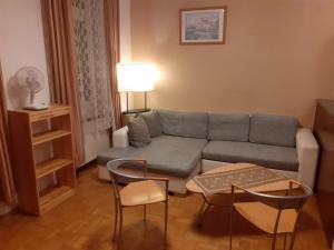 uma sala de estar com um sofá, uma mesa e cadeiras em HappyHostel em Viena