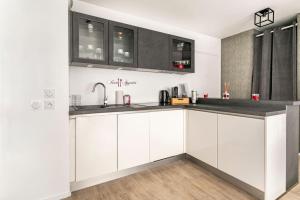 a kitchen with white cabinets and a sink at Appartement neuf Disney-Paris in Bonneuil-sur-Marne
