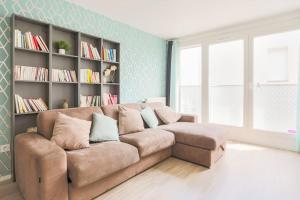 a living room with a brown couch and a book shelf at Appartement neuf Disney-Paris in Bonneuil-sur-Marne