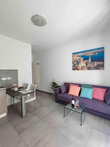een woonkamer met een paarse bank en een tafel bij Centeraly Located Cozy Apartment in Gzira in Il- Gżira