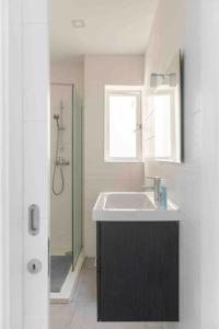 een witte badkamer met een wastafel en een douche bij Centeraly Located Cozy Apartment in Gzira in Il- Gżira