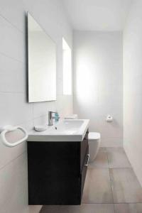 een witte badkamer met een wastafel en een toilet bij Centeraly Located Cozy Apartment in Gzira in Il- Gżira