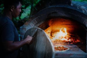 a person holding a pizza in a brick oven at Tailana Island Pulau Banyak in Alaban