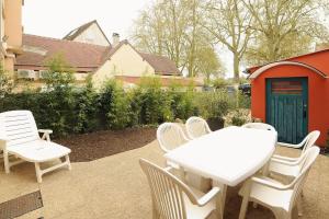 - une table et des chaises blanches sur la terrasse dans l'établissement Le Saint-Brice, à Chartres