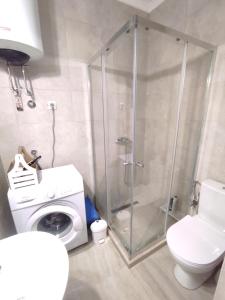 a bathroom with a shower and a washing machine at Apartment Clock Tower in Podgorica