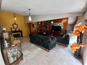Sala de estar con 2 sofás y TV en Margaritas Eco Haus, en Querétaro