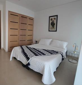 a bedroom with a large bed with a black and white blanket at Lujoso Apartamento Sector Morros Vista al Mar in Cartagena de Indias