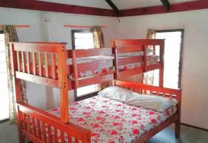 a red bunk bed in a room with two windows at Gold Coast Inn - Adults Only in Nanuya Lailai