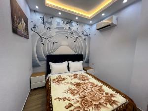 1 dormitorio con 1 cama con flores en la pared en HOTEL SYLBICA en Kolgecaj