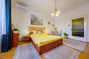 ブダペストにあるBalzac Apartmentのベッドルーム1室(黄色いシーツ付きのベッド1台、窓付)