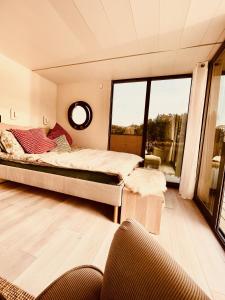 a bedroom with a bed and a large window at Hausboot Eisvogel in Kirchberg an der Raab