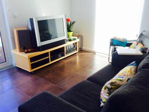 a living room with a couch and a television at Odeceixe Vila in Odeceixe