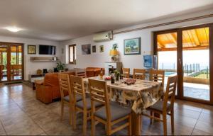 uma sala de jantar e sala de estar com mesa e cadeiras em Učka nature park mountain hideway robinson house Matić with pool em Brest