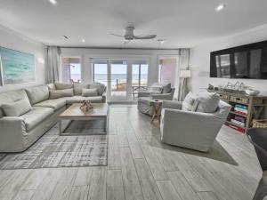 a living room with a couch and chairs and a tv at Three Steps to the Beach Townhouse in Inlet Beach