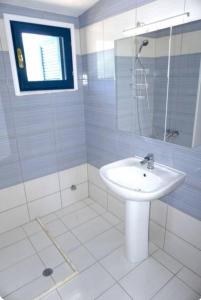 a white bathroom with a sink and a shower at Elvi Apartment 1 in Rachonio
