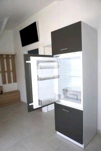 a kitchen with an empty refrigerator in a room at Elvi Apartment 1 in Rachonio