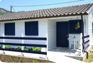 a white house with a blue door and a porch at Elvi Apartment 1 in Rachonio