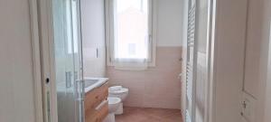 a bathroom with a toilet and a sink and a window at Casa Toe' Quinto in Quinto di Treviso