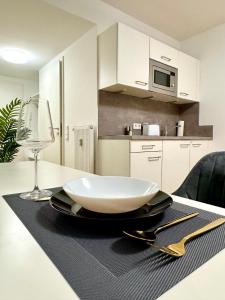 a white bowl on a table with a wine glass at Modernes Apartment nahe des Stadtzentrums in Hannover