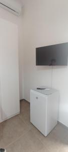 Eine weiße Küche mit Herd und Fernseher an der Wand in der Unterkunft B&B Ristel in Lizzano