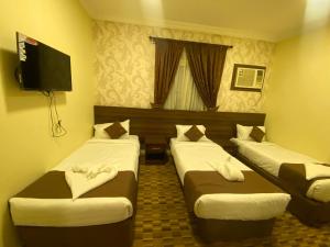 Een bed of bedden in een kamer bij مرجان أنوار الروضة