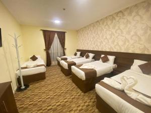 a hotel room with four beds in a room at مرجان أنوار الروضة in Makkah