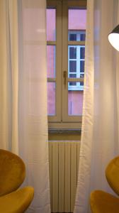 um quarto com uma janela com cortinas brancas em Ars Nova em Cuneo