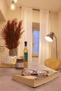 ein Buch mit einer Flasche Wein und Gläsern auf dem Tisch in der Unterkunft Ars Nova in Cuneo