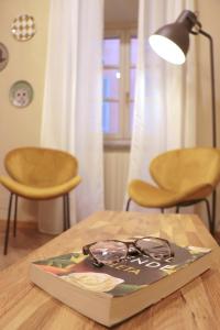 un libro con un par de gafas sentadas en una mesa en Ars Nova en Cuneo