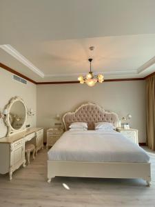 a bedroom with a bed and a vanity and a chandelier at Riviera Hotel in Dubai