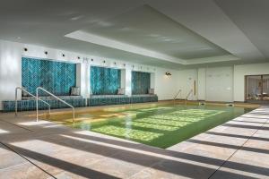 a swimming pool with green water in a building at Harbour Beach Club, Hotel & Spa in Salcombe