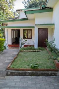 a house with a lawn in front of it at Kandy Boutique Villa by Aaradhya in Kandy