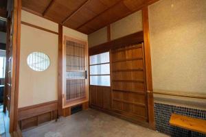 an empty room with a door and a window at countryside stay ゲストハウスもらいもん in Kanaya