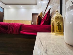 um quarto com um sofá vermelho e um objecto dourado numa mesa em COMFORTABLE STAY em Nova Deli