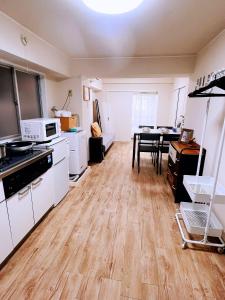 uma cozinha com armários brancos e uma mesa dentro em 交通便利 山手線池袋駅 徒歩6分 東池袋駅徒歩3分 2~5人 エレベーター WIFI 新宿/渋谷/銀座/築地/浅草/原宿近い！ em Tóquio