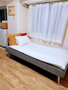 uma cama sentada em um quarto com janela em 交通便利 山手線池袋駅 徒歩6分 東池袋駅徒歩3分 2~5人 エレベーター WIFI 新宿/渋谷/銀座/築地/浅草/原宿近い！ em Tóquio mais 21 fotografias