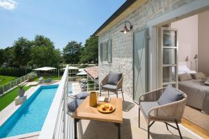 eine Terrasse mit einem Tisch und Stühlen neben einem Pool in der Unterkunft Villa Elena u Ladicima for 8 people with private pool & sports complex in Central Istria in Ladići