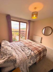 a bedroom with a bed and a large window at Bright 2bed Flat Milton Keynes in Milton Keynes