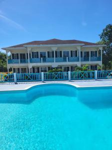 una casa grande con una gran piscina frente a ella en The Resort at West End en Negril