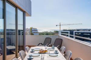 uma mesa e cadeiras numa varanda com vista em Breathtaking Coral Ocean View Apartment at OA em Portimão