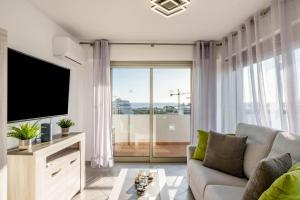 a living room with a couch and a flat screen tv at Breathtaking Coral Ocean View Apartment at OA in Portimão