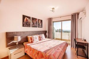 a bedroom with a bed and a desk and a window at Breathtaking Coral Ocean View Apartment at OA in Portimão +63 photos