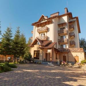 duży budynek przy brukowanej ulicy w obiekcie Ведмежа гора Family Resort & Spa w Jaremczach