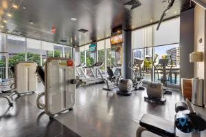 einen Fitnessraum mit Kardiogeräten in einem Gebäude mit Fenstern in der Unterkunft Modern Resort - Apartment with Balcony, Pool and Gym in Hallandale Beach