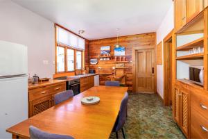 a kitchen with a wooden table and a dining room at Forest House Methven in Methven