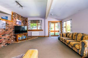 a living room with a couch and a television at Forest House Methven in Methven