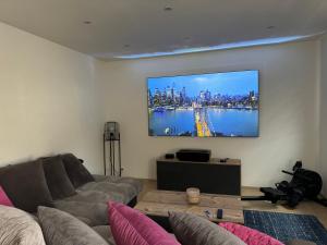 a living room with a couch and a tv on the wall at Jolie maison avec Salon Cinéma in Mouy +10 photos