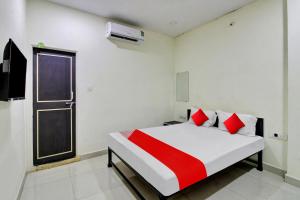 a bedroom with a bed with red pillows and a window at OYO Flagship Hotel Green Farm in Nagpur