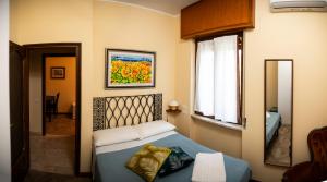 Schlafzimmer mit einem Bett, einem Fenster und einem Spiegel in der Unterkunft Villa Aldo e Lalla in Rozzano